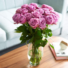 bouquet in glass vase of Purple Attraction Long Stem Roses have a hint of lavender in the center
